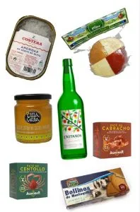 Image showing a variety of Spanish gourmet products: anchovies in olive oil, a soft cheese, a bottle of natural cider, a cider sweet, scorpion fish and spider crab pรขtรฉ, and butter rolls.